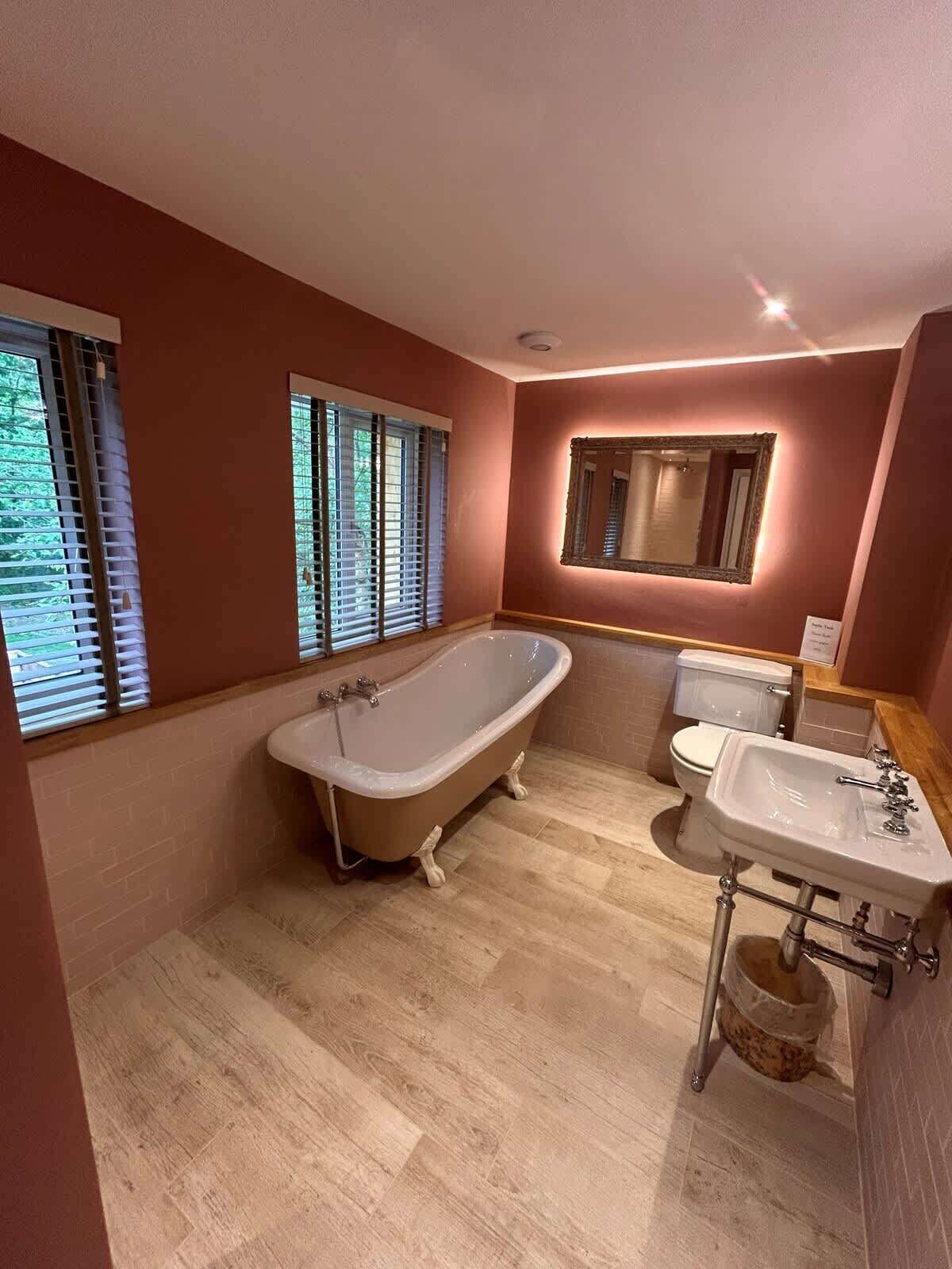 A bathroom with a freestanding bathtub, a toilet, and a sink.