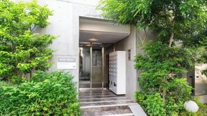 A building entrance with a 'FOR RENT' sign, a staircase, and a vending machine. - LEGALAND Sangenjaya ANNEX (Tokyo)