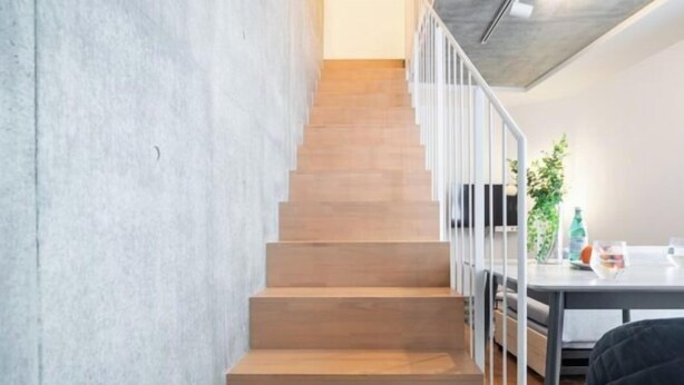 A staircase with wooden steps and white railings, leading to a room with a table and a plant. - LEGALAND Sangenjaya ANNEX (Tokyo)