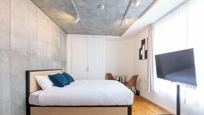 A modern bedroom with a bed, a TV, a desk, and a chair. - LEGALAND Sangenjaya ANNEX (Tokyo)