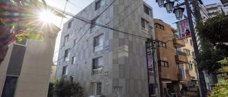 A multi-story building with a modern architectural design, featuring a prominent corner and a visible entrance.