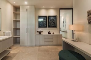A modern bathroom with a large cabinet, a vanity with a mirror, and a towel rack. - OMEKAI Cemagi by Nakula (Bali)