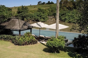 A pool area with a gazebo, lounge chairs, and a white canopy. - OMEKAI Cemagi by Nakula (Bali)