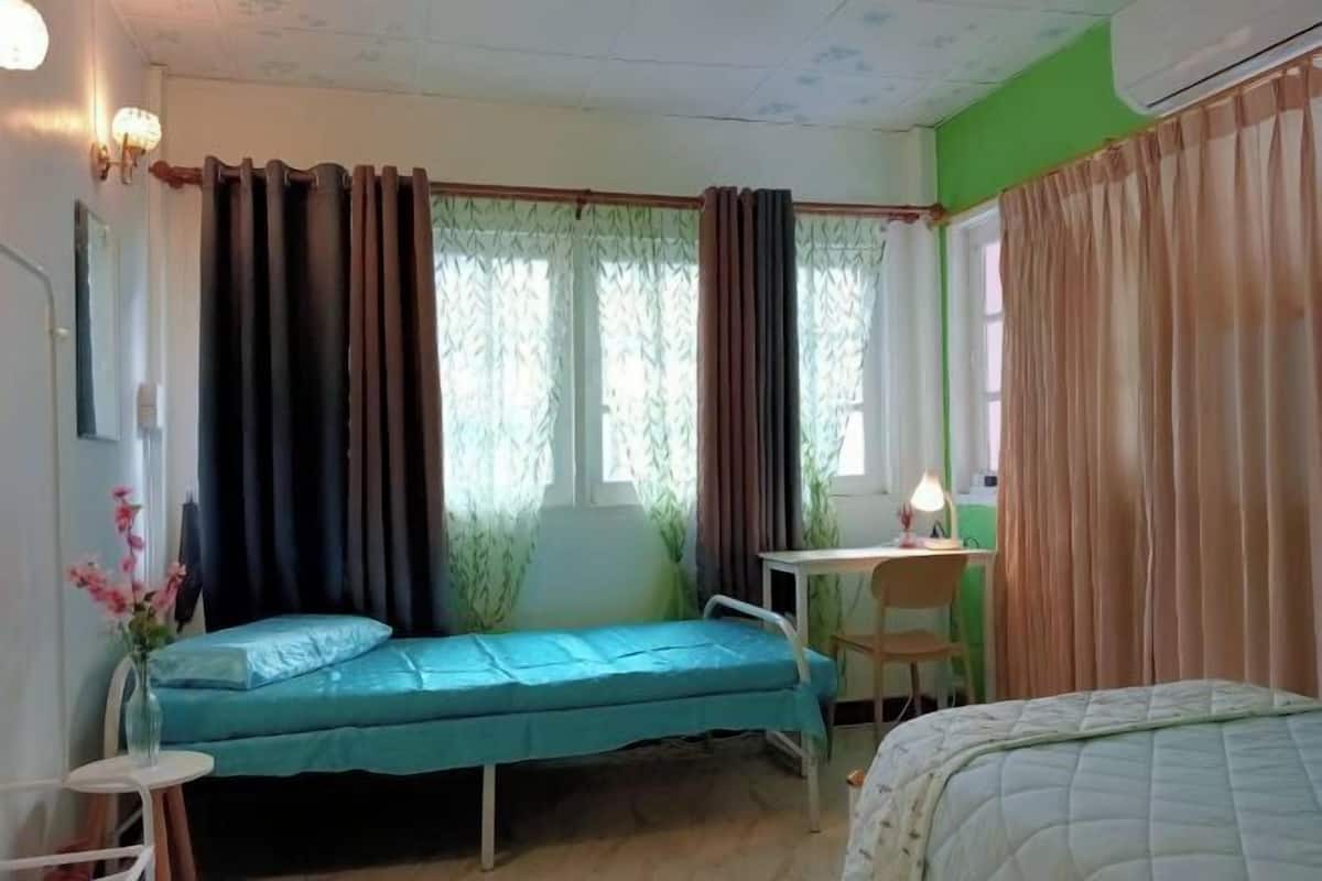 A small, single-room accommodation with a bed, a desk, and a chair.