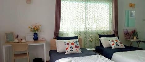 Een slaapkamer met twee bedden, een bureau en een stoel.