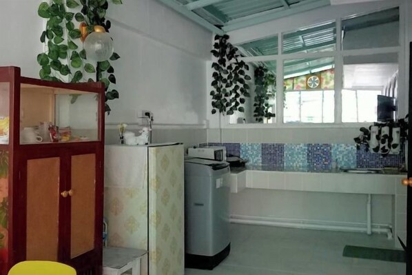 A kitchen with a refrigerator, microwave, and a window with a view. - Ban Suanlum (Bangkok)