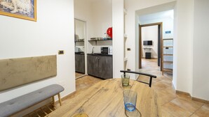A dining area with a wooden table, a bench, and two glasses. - Dimora Stella by Wonderful Italy (Naples)