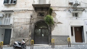 A building with a large arched entrance, a scooter parked in front, and a door with a number '31' above it. - Dimora Stella by Wonderful Italy (Naples)
