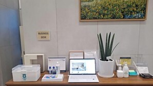 Escritorio de oficina con una computadora portátil, una planta y diversos útiles.
