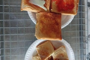 A tray of toasted bread slices with jam and a small bowl of toast. - Keangvarin Resort (Pak Chong)