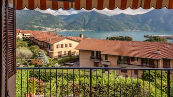 Un balcon avec vue sur une ville, des montagnes et un lac.
