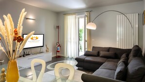 Ein modernes Wohnzimmer mit einer Couch, einem Glastisch und einer Vase mit Pampasgras.