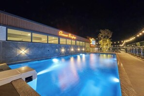 A swimming pool with a building adjacent to it, featuring a neon sign. - Bcons PS Bien Hoa Hotel (Bien Hoa)