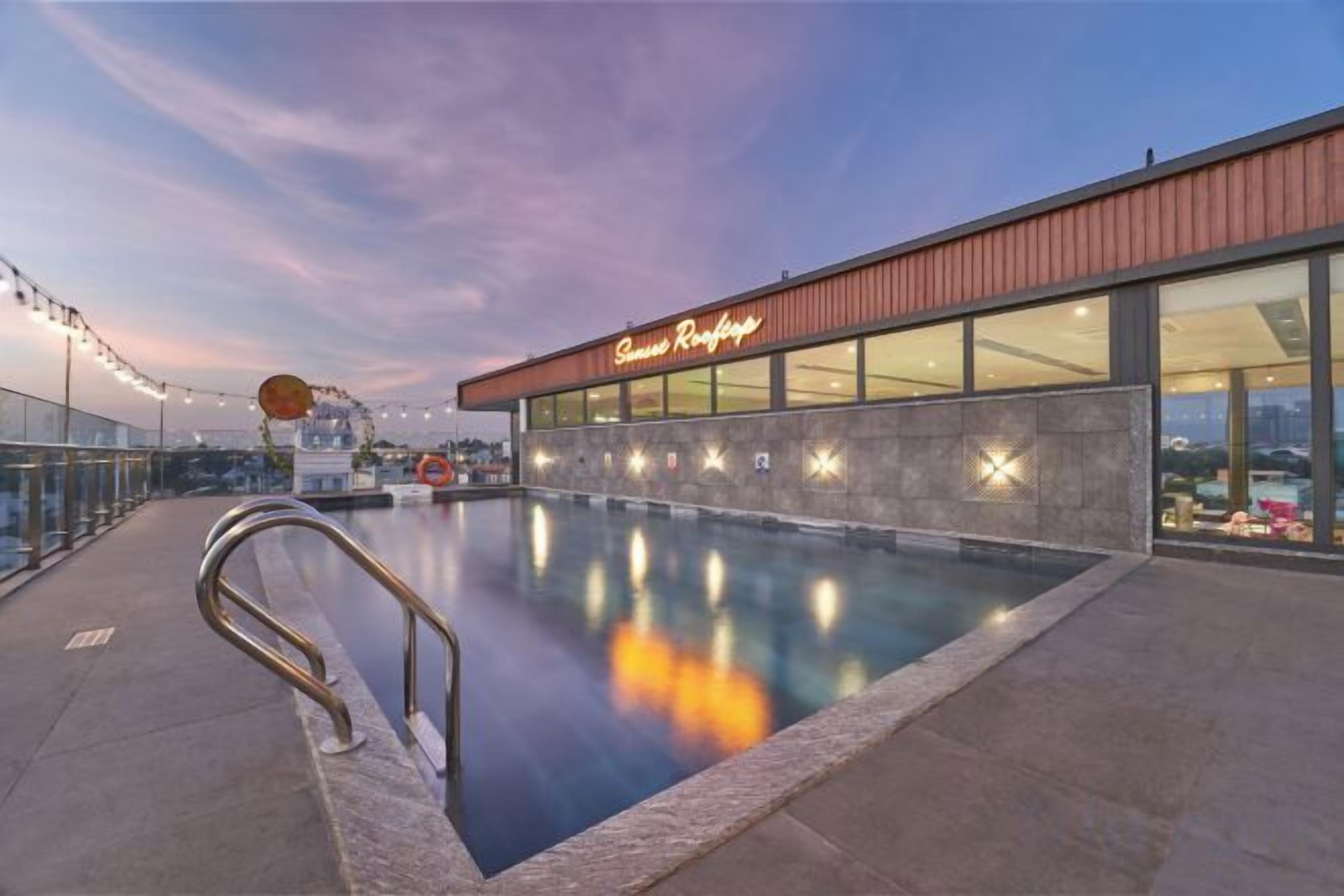 A swimming pool adjacent to a building with a sign that reads 'Beach Resort.'