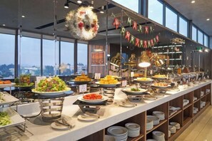 Un buffet proposant une variété de plats, une décoration de Noël et une vue dégagée grâce à de grandes fenêtres.