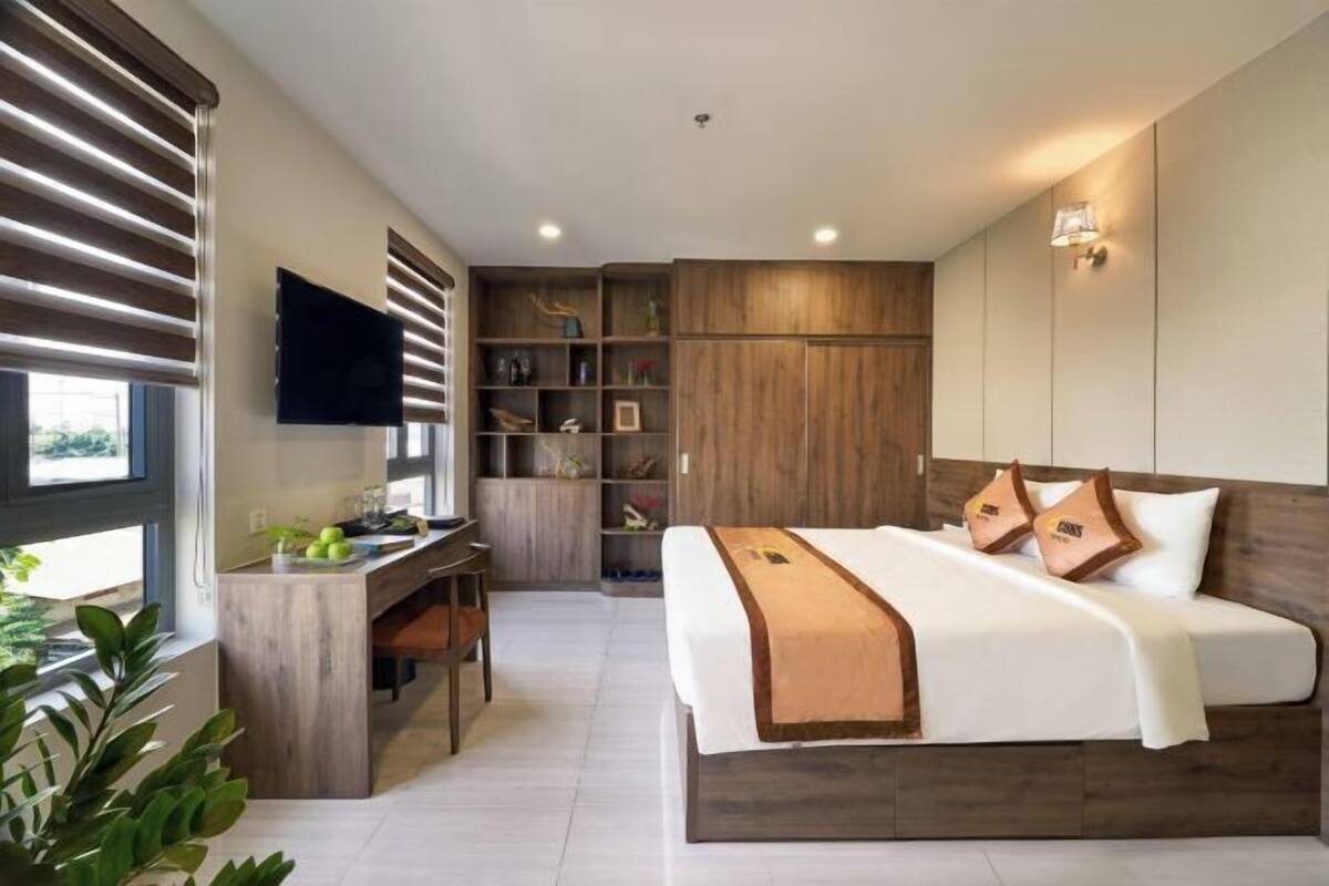 Un dormitorio con una cama, un escritorio y un televisor.