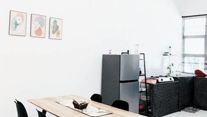 A modern kitchen with a wooden table, black tiled counter, and a refrigerator. - D' Splash Garden Homestay Baling (Baling)