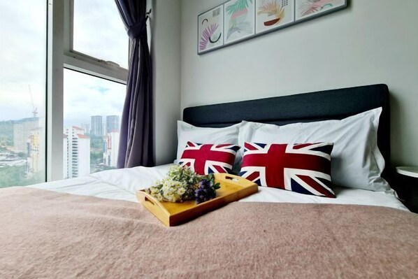 A bed with a wooden tray of flowers, a view of buildings through a window, and a wall with framed artwork. - Broad 7 Guest Scott Garden / Old Klang Road / Bangsar South / Mid Valley / Kuala Lumpur (Kuala Lumpur)