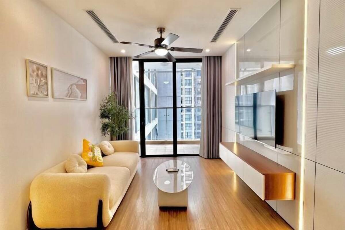 Una sala de estar moderna con un sofá, una mesa de centro y un televisor montado en la pared.