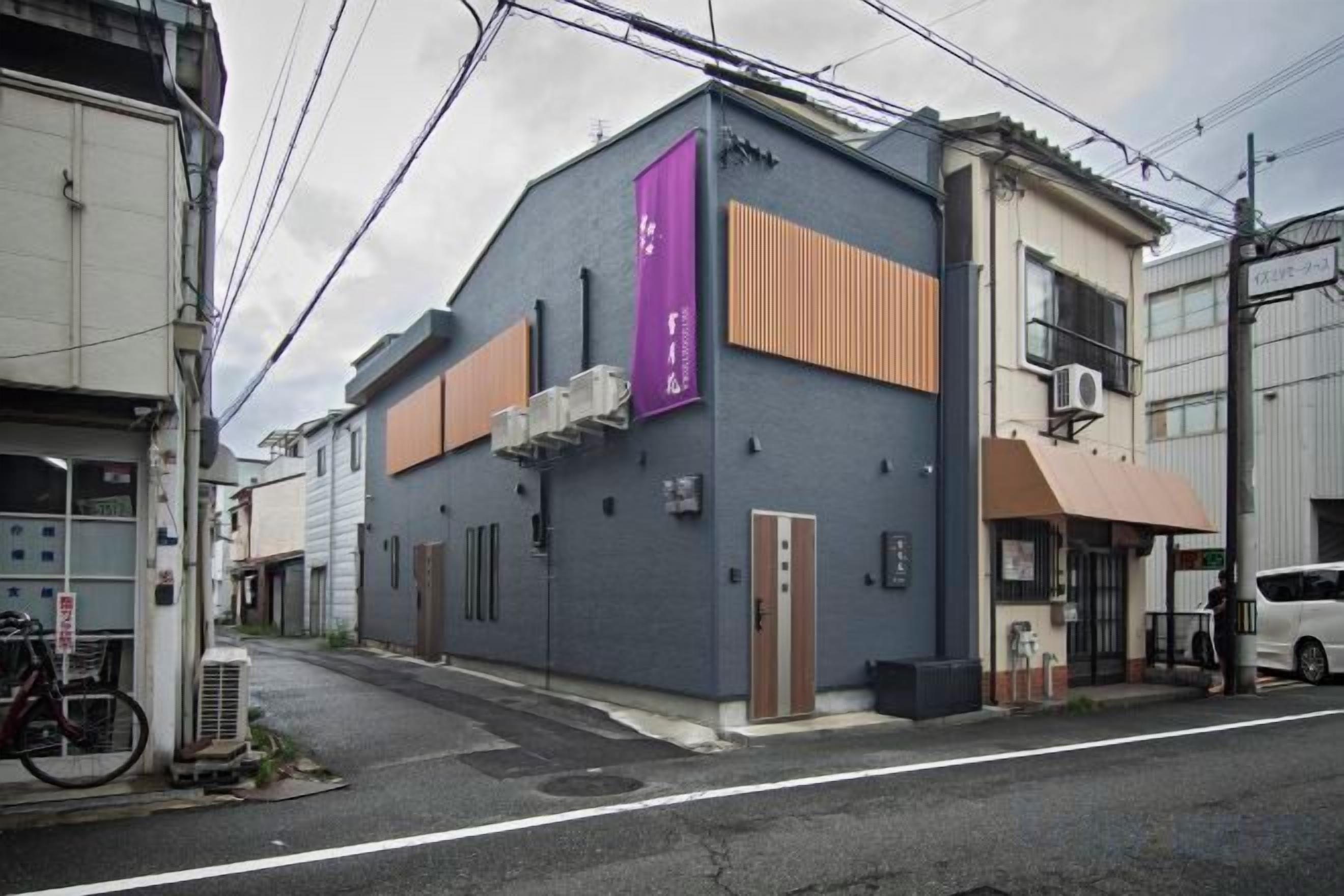 A building with a flat facade, a purple banner, and a parked bicycle.