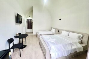 A bedroom with a bed, a desk, two chairs, a TV, and a shower area. - Skyinn Resort (Khok Samrong)