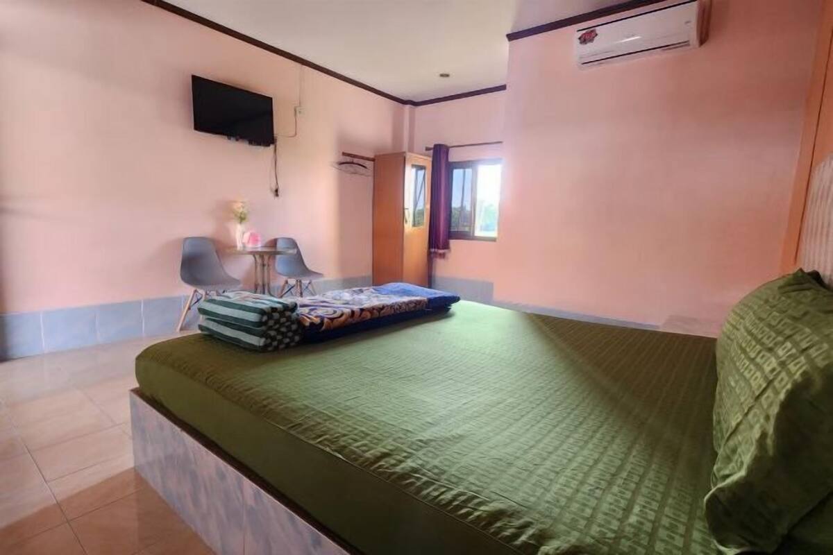 Ein Hotelzimmer mit Bett, Schreibtisch, Stuhl und Klimaanlage.
