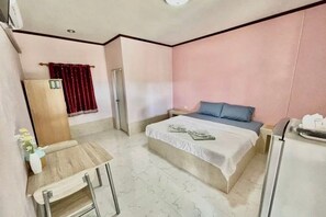 A hotel room with a bed, a small table, a chair, a wardrobe, and a bathroom. - Skyinn Resort (Khok Samrong)