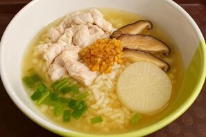 A bowl of soup with chicken, mushrooms, corn, and green onions. - Skyinn Resort (Khok Samrong)