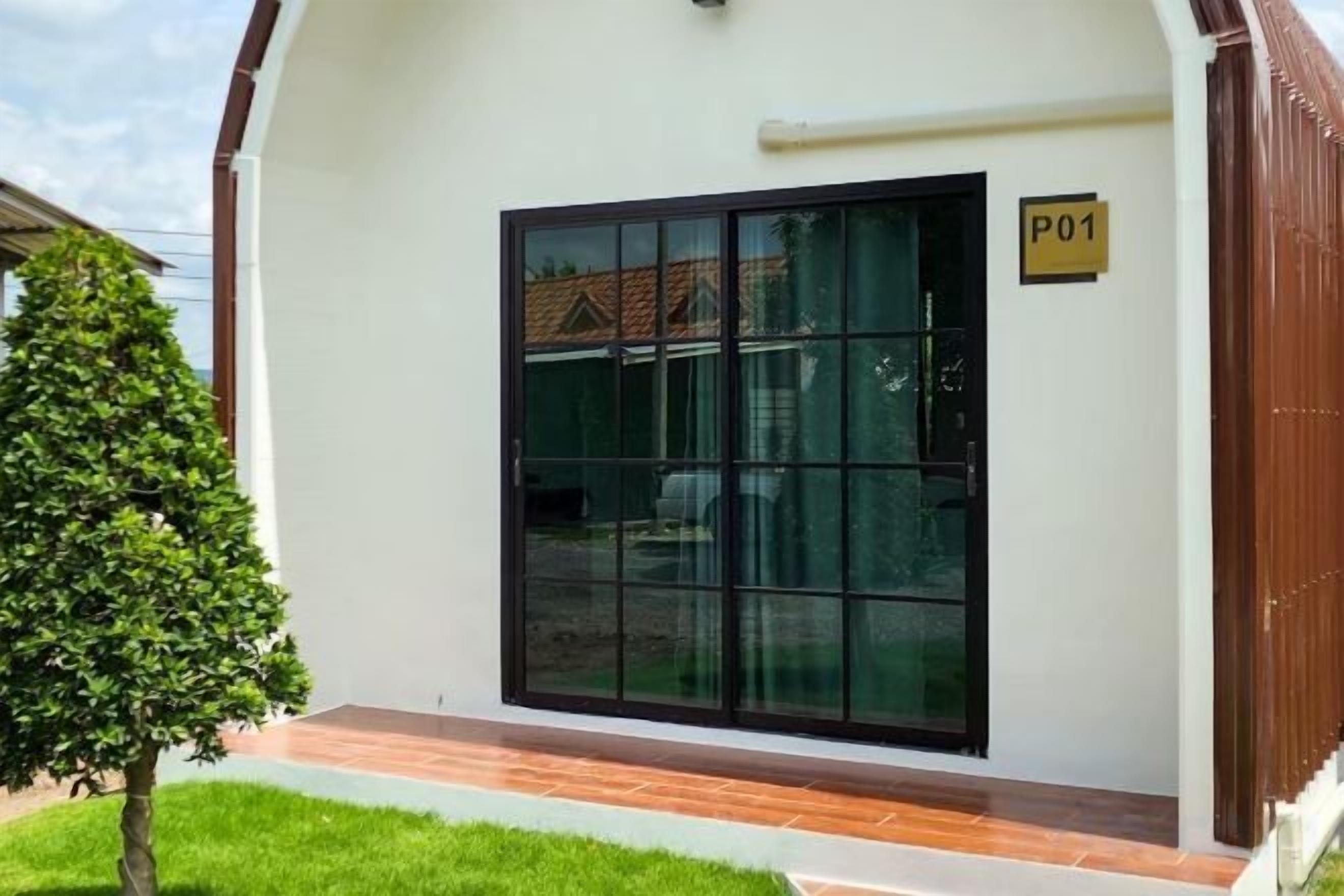 A building with a large glass door, a small tree, and a sign with 'P01'.