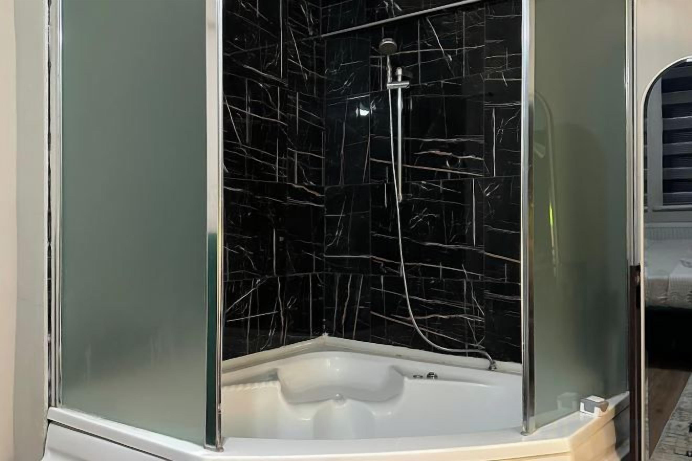 Un baño con cabina de vidrio, ducha y bañera.