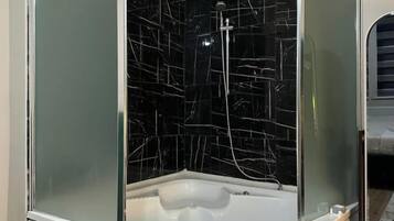 Un baño con cabina de vidrio, ducha y bañera.