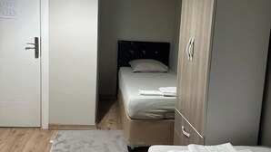 Un dormitori amb un llit, un armari i una porta.