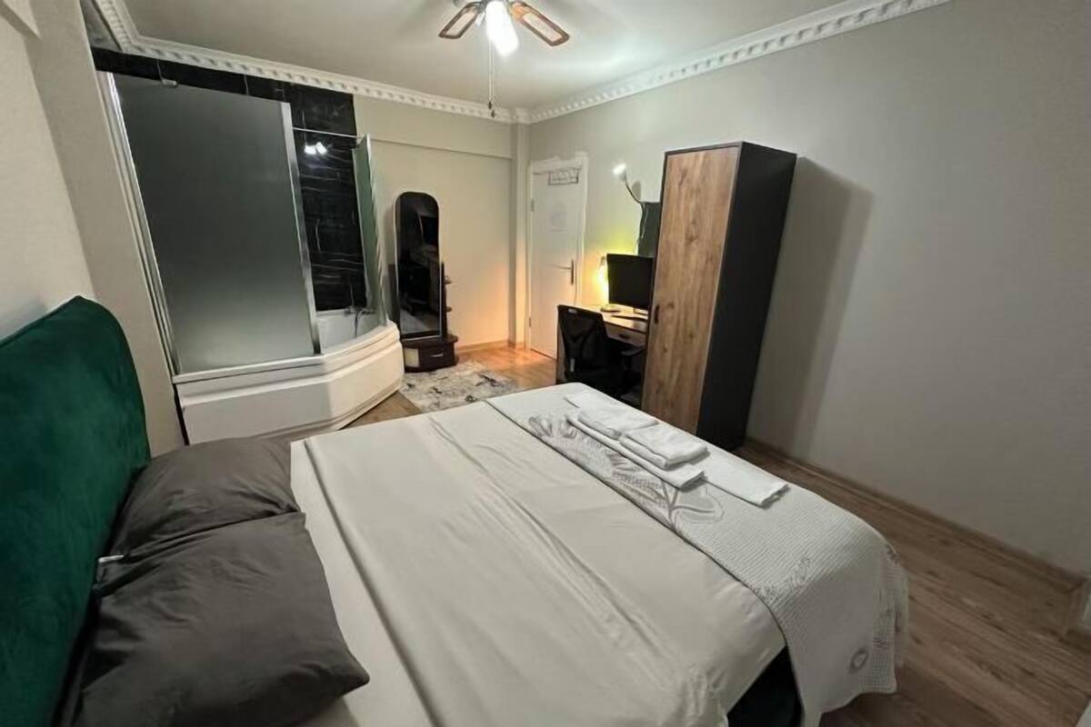 Une chambre à coucher avec un lit, un miroir, un bureau et une armoire.