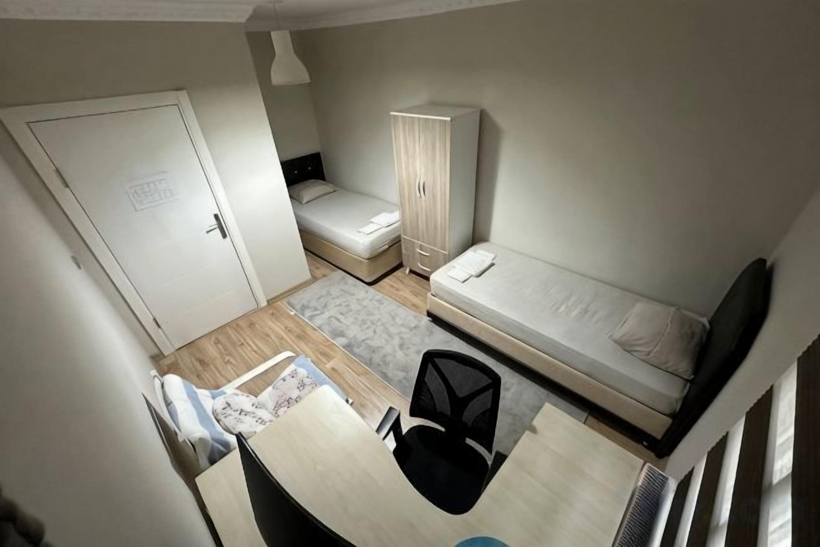 A compact room with a bed, a desk, a chair, and a wardrobe.