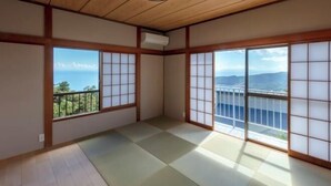 A traditional Japanese room with tatami flooring, shoji screens, and a view of a bridge. - The Villas〜atami amazing ocean view〜 (Atami)