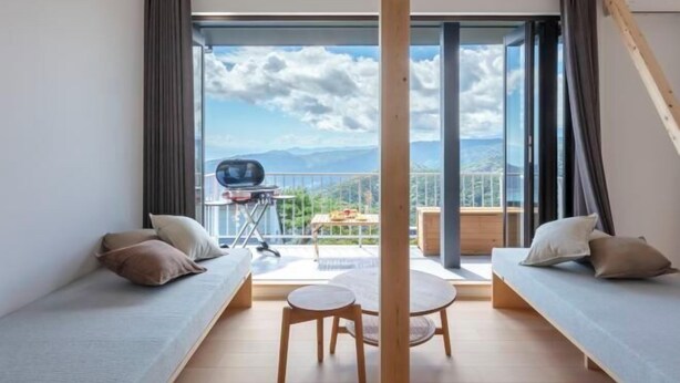 A modern room with a balcony, a small table, and two sofas. - The Villas〜atami amazing ocean view〜 (Atami)