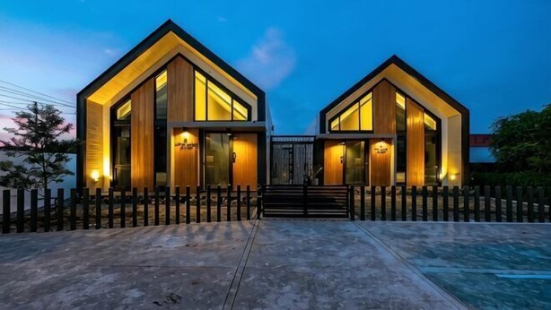 A modern two-story building with a symmetrical design, featuring large windows and a central entrance. - Baan Ga-cha (Chiang Rai)
