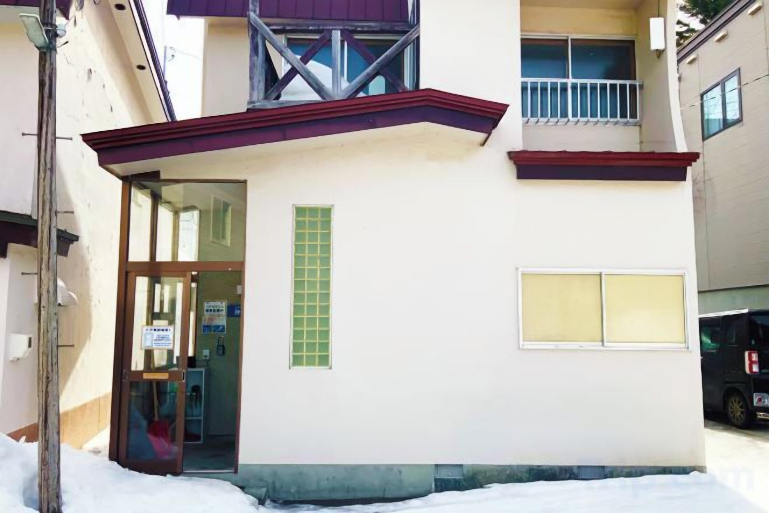 A building with a door, a window, and a balcony.