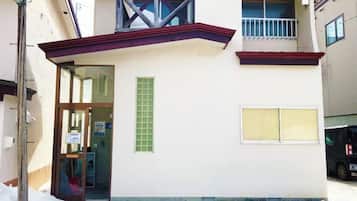A building with a door, a window, and a balcony.