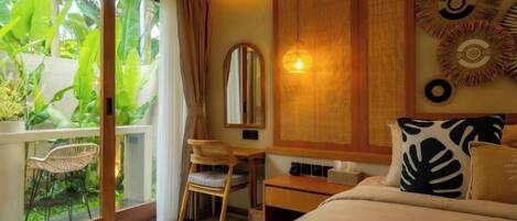 Habitación de hotel con cama, escritorio, silla y ventana grande con vistas a zonas verdes.