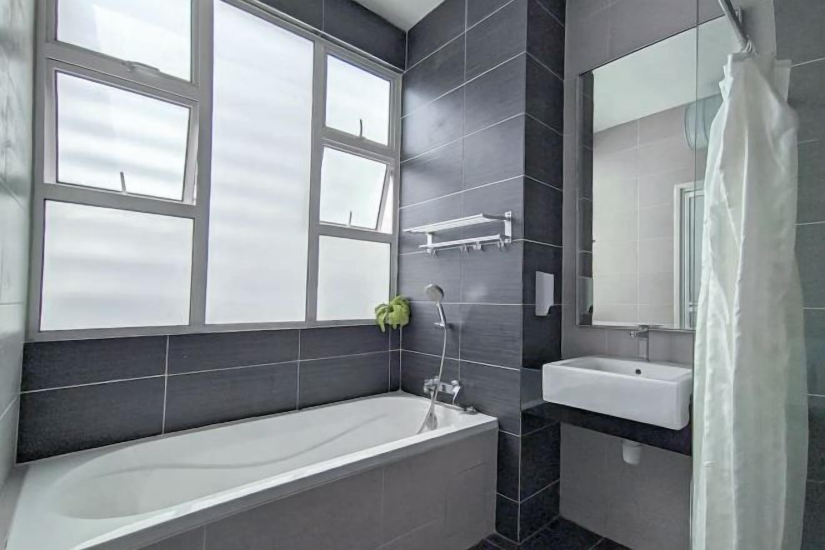 A modern bathroom with a bathtub, a sink, and a large window.