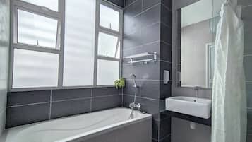 A modern bathroom with a bathtub, a sink, and a large window.