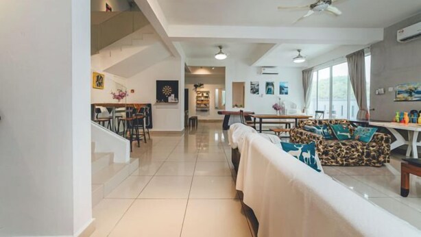 A spacious living area with a sofa, a dining table, and a staircase. - d'Fun Desaru 16-20pax Private pool / BBQ / KTV (Bandar Penawar)