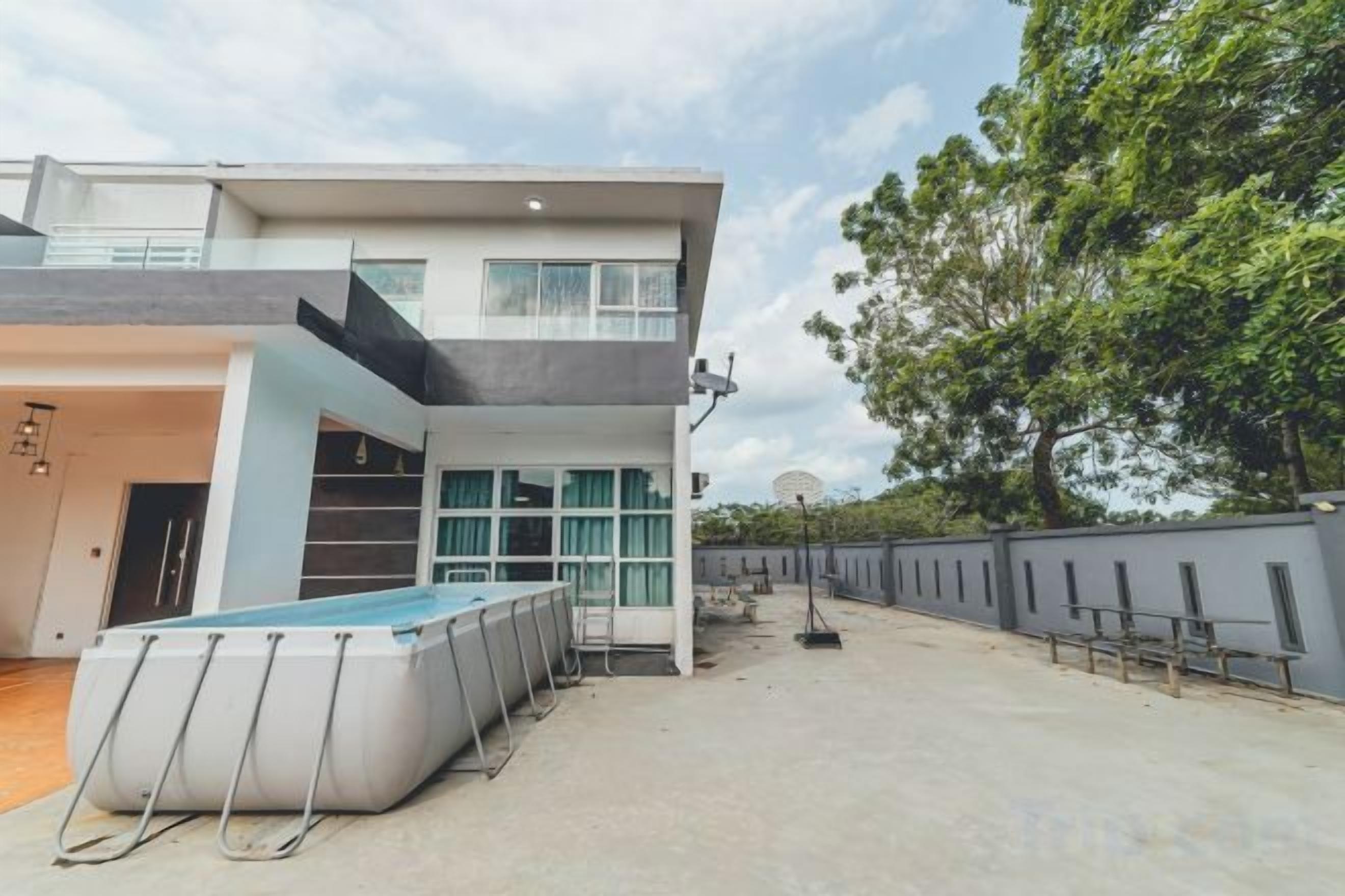 Une maison moderne à deux étages, dotée d’une piscine, d’un patio couvert et d’une cour clôturée.