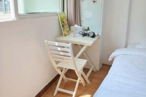 A small room with a bed, a desk with a chair, and a window. - QINGHE HOME (Seoul)