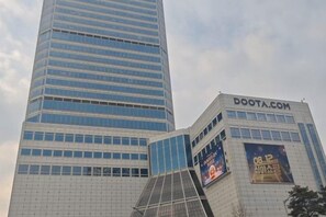 A modern building with a prominent DOOTA.COM sign and a large digital billboard. - QINGHE HOME (Seoul)