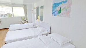 A hotel room with three single beds, a small table, and a window with curtains. - QINGHE HOME (Seoul)