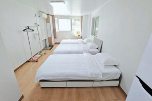A hotel room with three beds, a wardrobe, a bedside table, and a window. - QINGHE HOME (Seoul)