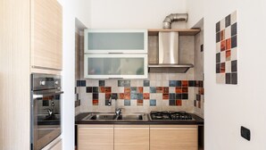 A modern kitchen with a stainless steel range hood, double sink, and built-in oven. - Casa Pellicani by Wonderful Italy (Bari)