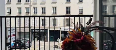 A building with multiple windows and a black metal fence in the foreground.
